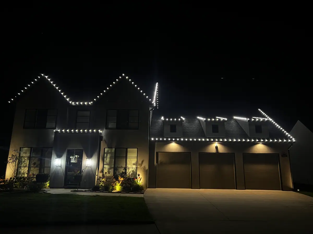 A modern two-story home outlined in crisp white lights along every roofline and gable